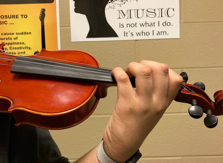 Violin held by a student with perfect left hand shape and posture