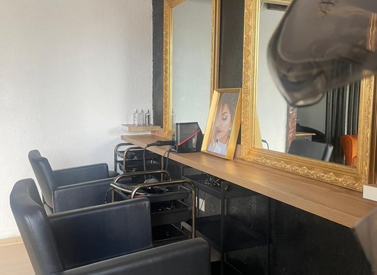 Vue intérieure du salon X Tension NC avec fauteuils professionnels et miroir doré, un espace dédié à