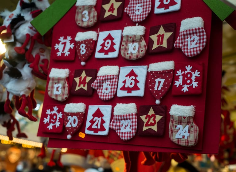 Red felt Christmas advent calendar featuring numbered pockets shaped like mittens, stars, and trees.