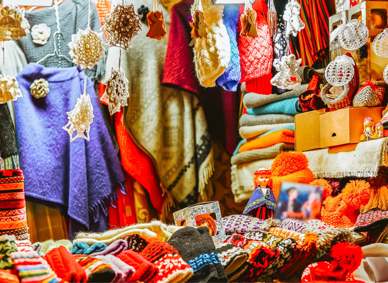 Handmade wool mittens, hats, and scarves displayed at a festive Christmas market stall.