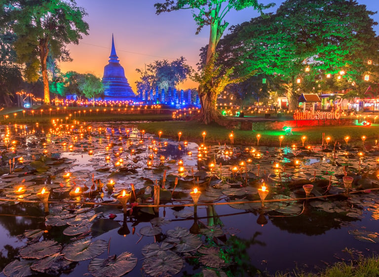 Floating candles on a lotus pond at Sukhothai Historical Park during the Loy Krathong festival in Thailand.