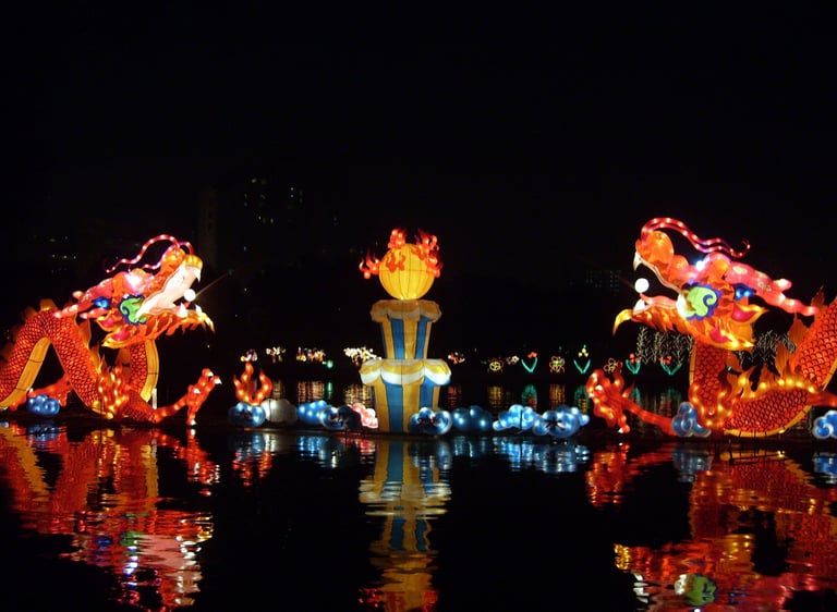Illuminated Chinese dragon lanterns reflecting on water during a traditional Mid-Autumn Festival display.