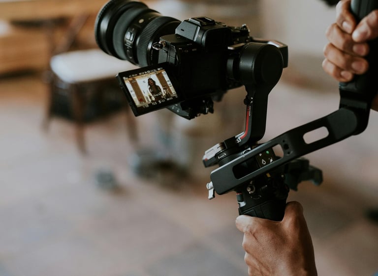 A videographer uses a professional gimbal stabilizer and mirrorless camera for video production.