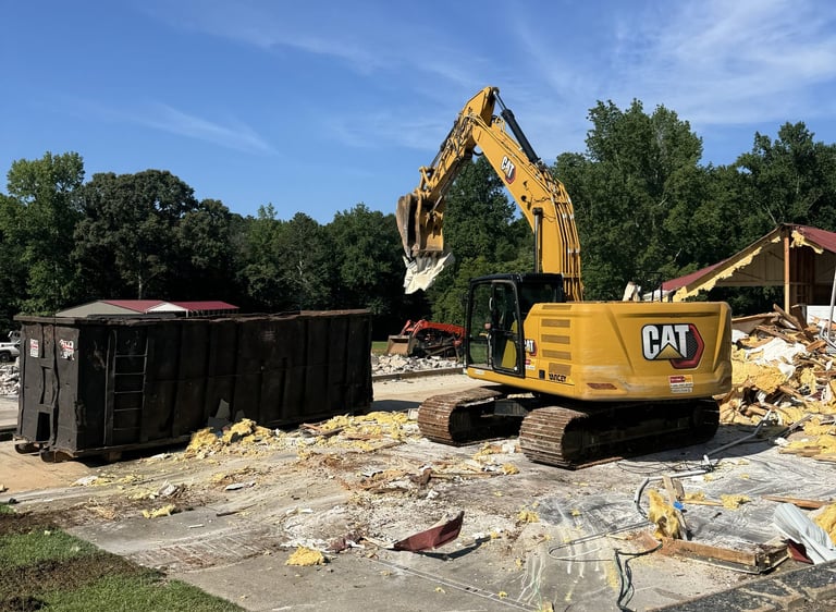 Excavator loading materials on a residential demolition site