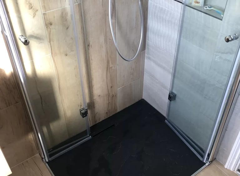 Newly installed walk-in shower with glass doors and tiled walls in Brighton bathroom remodel.