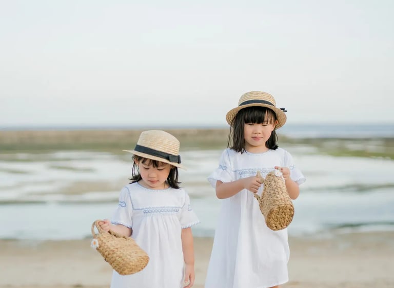 Two sisters standing together on the beach at The Apurva Kempinski Bali.