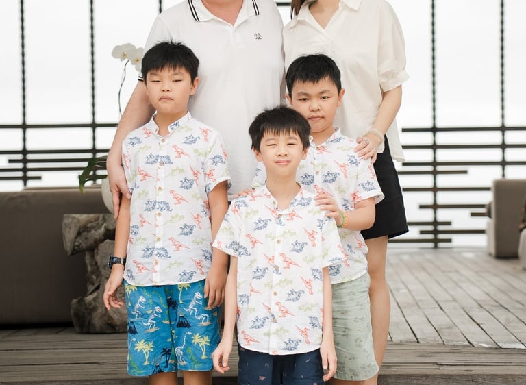 Family portrait on wooden deck at Alila Villas Uluwatu Bali with relaxed natural expressions