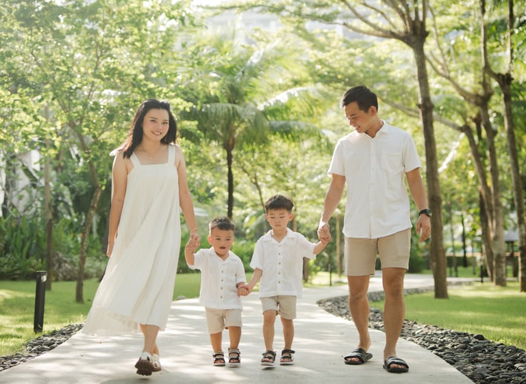 Parents walking with their children through tropical garden pathways at The Apurva Kempinski Nusa Dua Bali