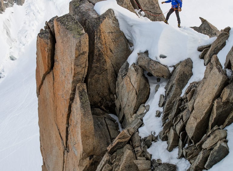 deux alpinistes sur une arrête rocheuse enneigée