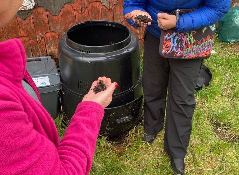 Equipo EcoRumbo enseñando a la comunidad uso de compostera en educación ambiental.