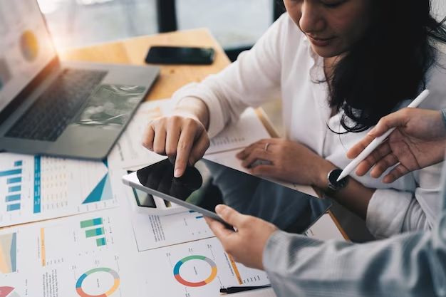 a man and woman sitting at a desk with a tablet