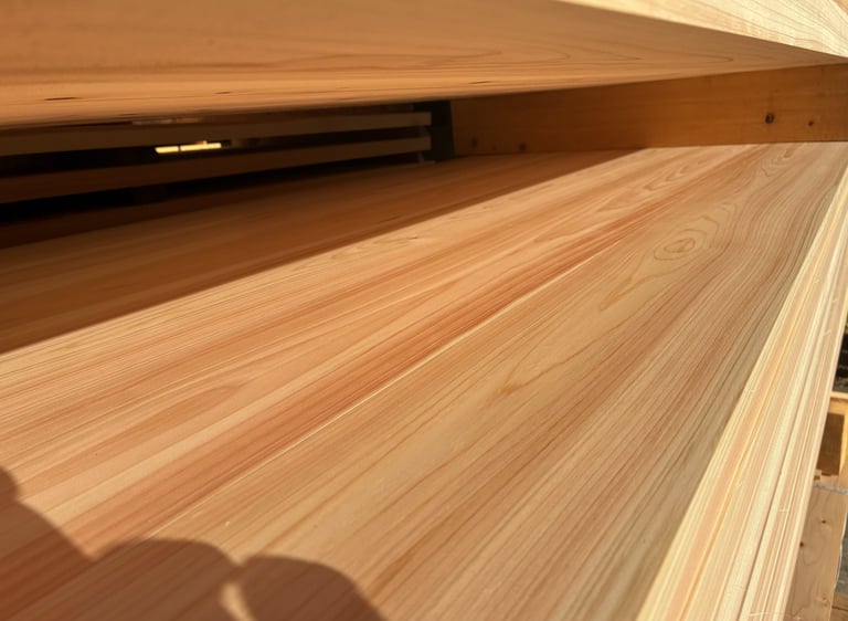 Close-up of smooth, light-colored cypress wood planks stacked at a lumber yard.