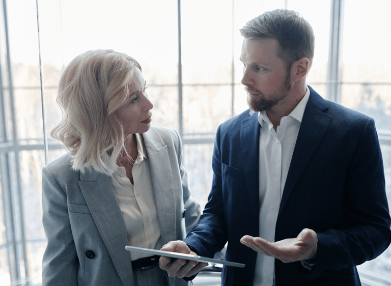 un hombre y una mujer de pie frente a una ventana