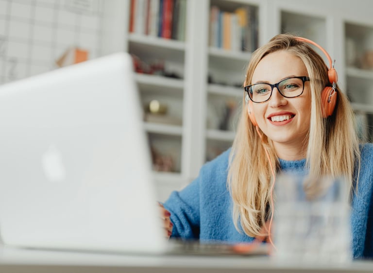 a woman wearing and sitting at a desk with her laptop