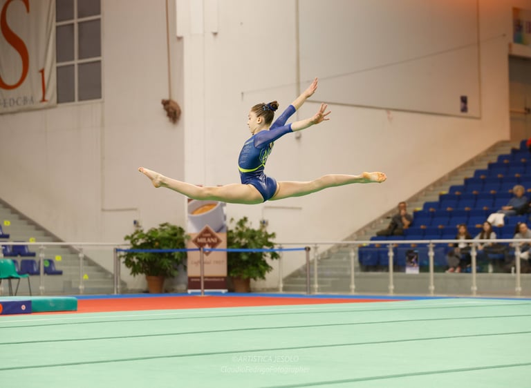Gymnast performing a high split leap jump at PAla Turismo Jesolo