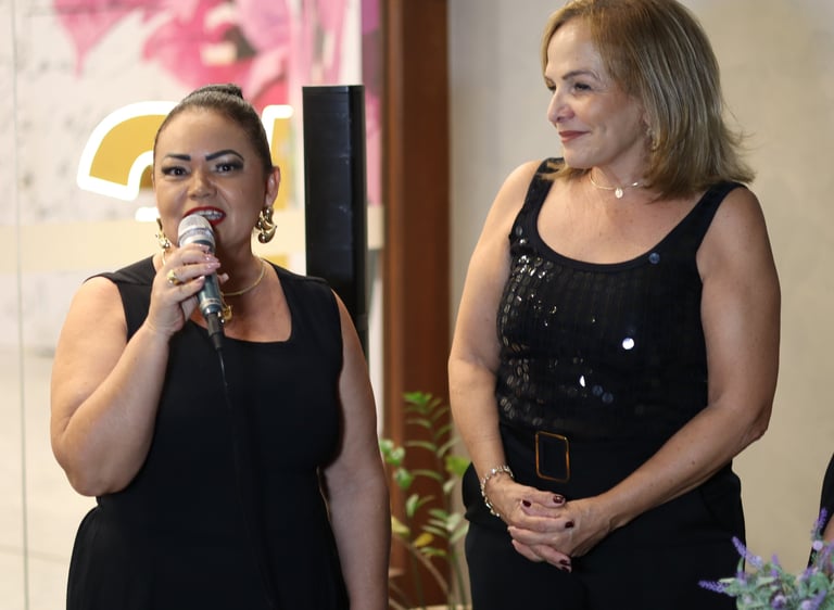 Duas mulheres de preto falando ao público