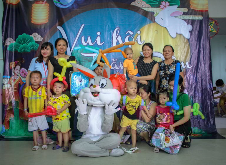 a group of people posing for a photo with a bunny on the ground