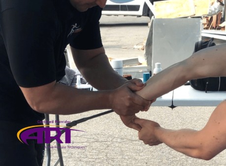 Thérapeute pratiquant la technique Active release technique ART  lors d'une compétition de crossfit. 