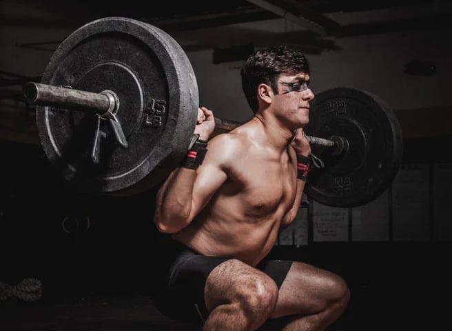"Une personne effectuant un exercice de CrossFit, faisant preuve de force et d'endurance en soulevant un haltère 