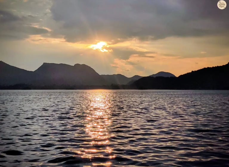 Warm golden reflections shimmering across Fateh Sagar udaipur during sunset.