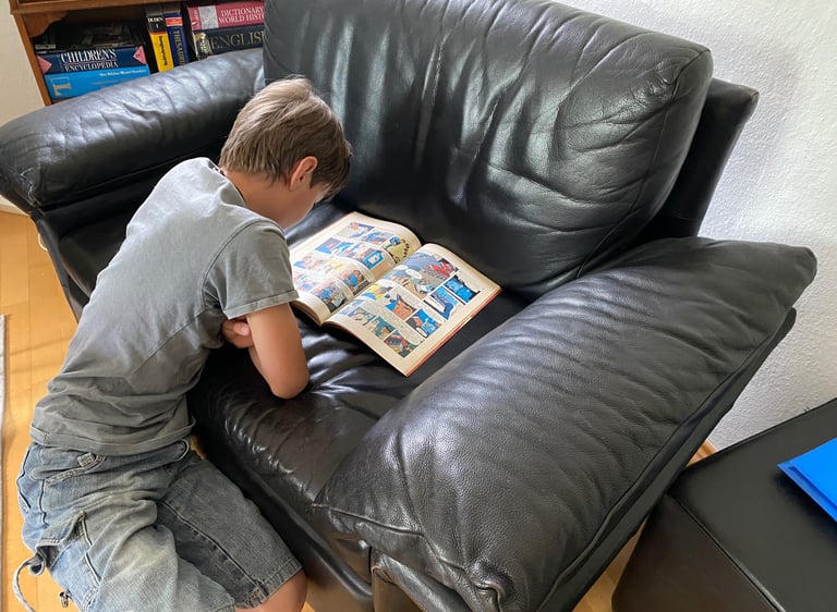 Junge liest fasziniert ein Comic-Heft