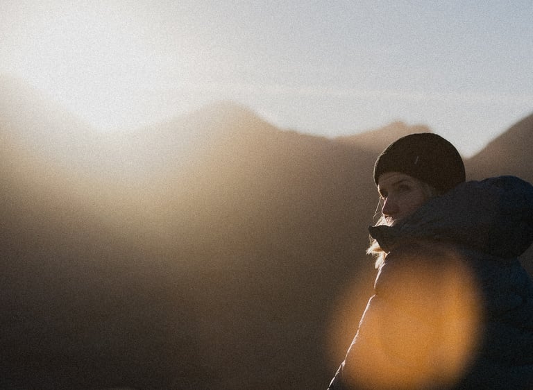 a photo of sunny winetr day in the mountains of scotland girl in a hat