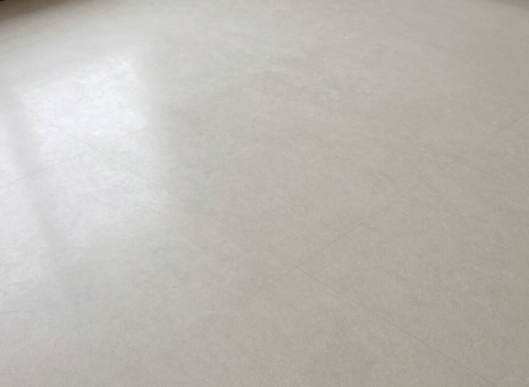 Shiny polished floor surface reflecting soft indoor lighting in a modern room.