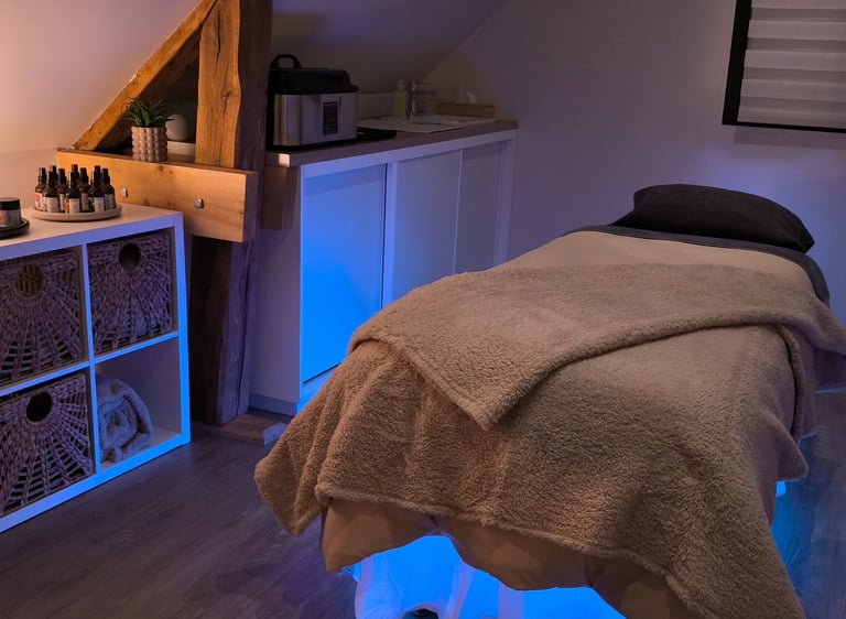 Une cabine de soin pour le massage, avec une table de massage et des huiles de massage