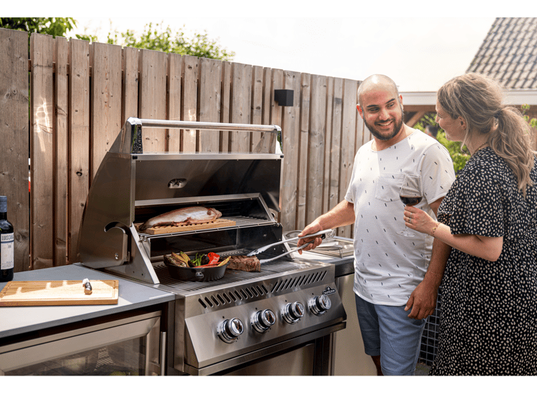 Couple cooking on a professional Napoleon built in grill integrated into modular cabinetry