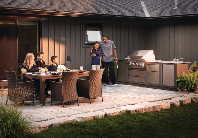 Family enjoying a backyard patio with a Napoleon Oasis modular kitchen setup