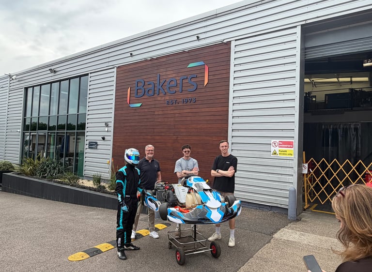 A group of people posing with Burwood Motorsports racing kart outside Bakers Labels factory