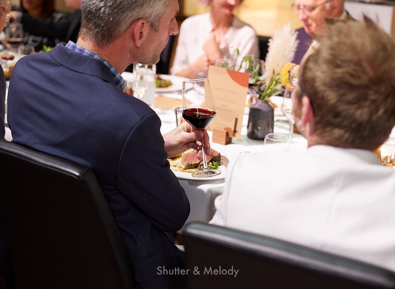 Ein Gast beim Abendessen genießt ein Glas Rotwein.