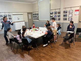 Kid's sitting around tables, engaged in activities