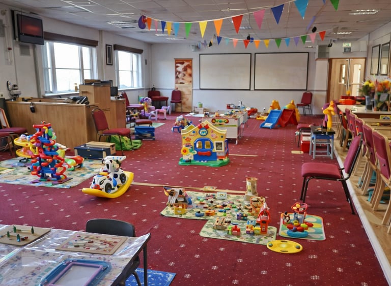 Play area inside New Life Church baby & toddler group in Saffron Walden with toys, soft play, slides and seating for parents.