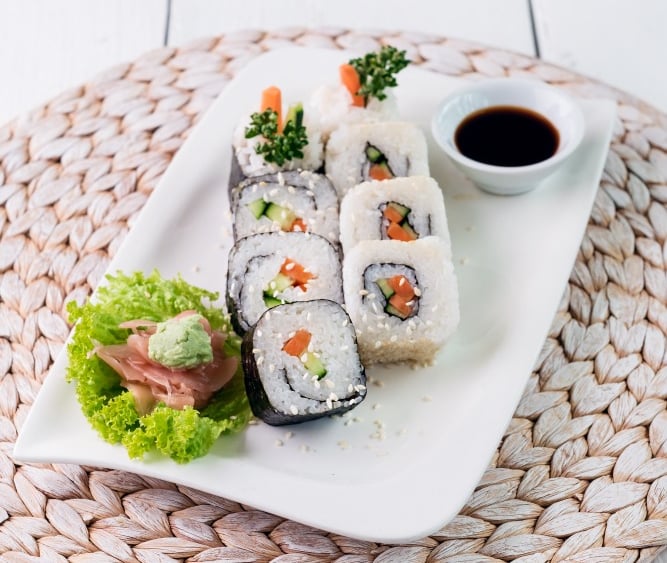 a plate with veggie sushi and sauce