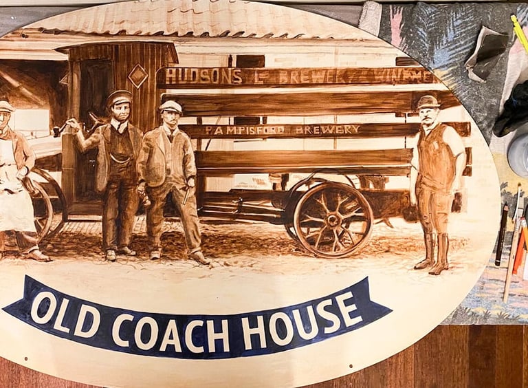 Close-up of pub sign with painted brewery staff