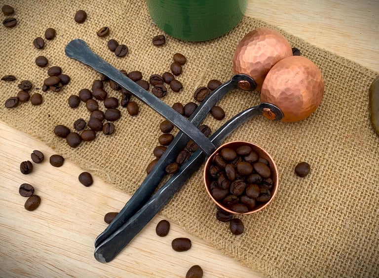 a pair of spoon and coffee beans on a table