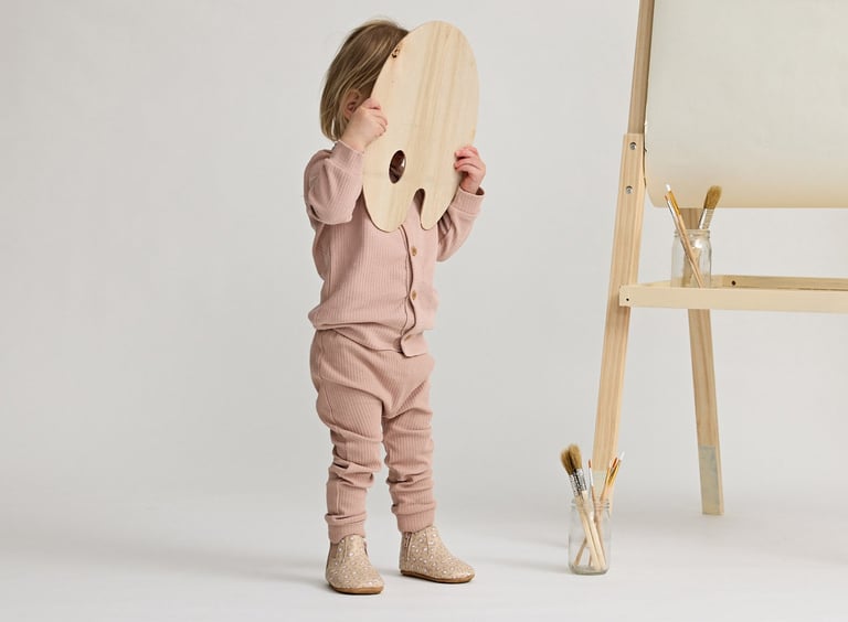 Fashion campaign photography - a little girl standing in front of a easel