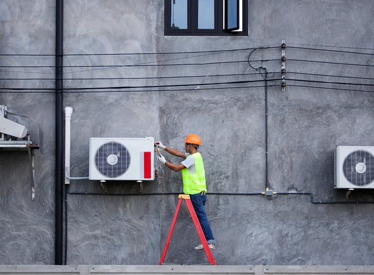 Professional HVAC technician in safety gear repairing an outdoor air conditioning unit on a ladder.