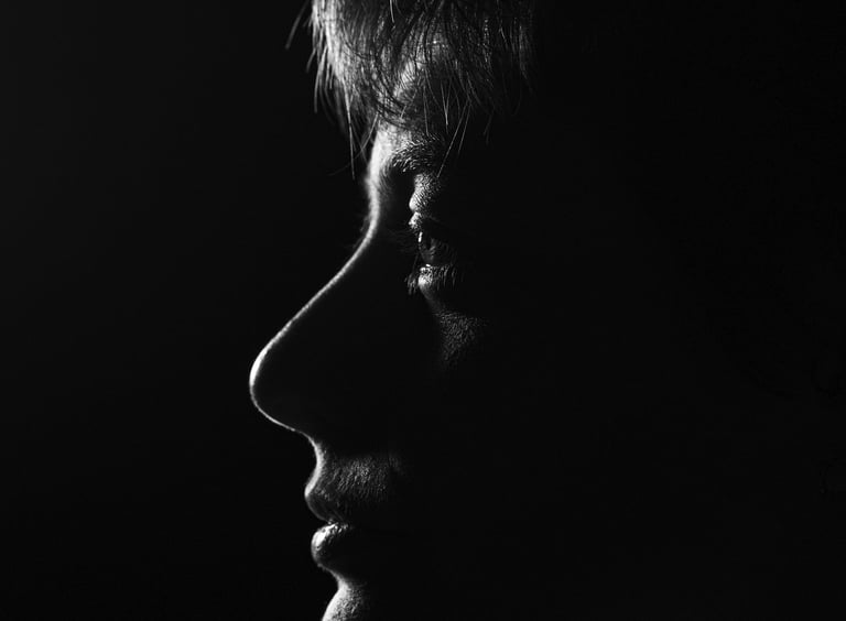 Dramatic black and white profile silhouette of a person's face using low-key lighting.