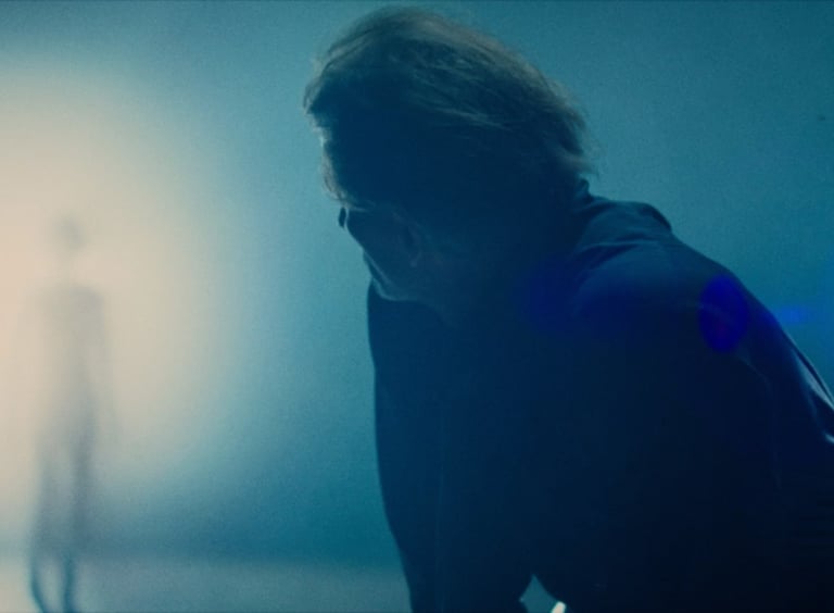 Older Self scene of an Individual approaching Tom Michaels from the light