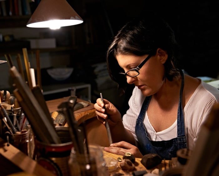 Artesana joyera utilizando herramientas profesionales para crear joyería personalizada en un taller