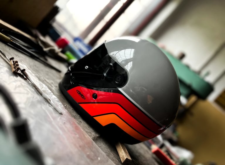Kask neoklasyczny DMD Rivale w malowaniu Blade na stole w garażu