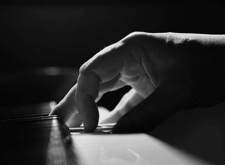a person's hand is touching the keyboard of a piano