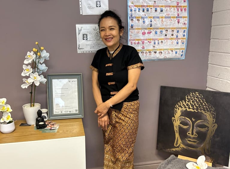 a Thai woman in traditional costume standing in front of a wall with a clock