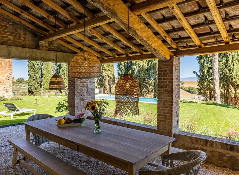 Grande tablée sous la pergola de Villa Violetta avec vue sur le parc et la piscine