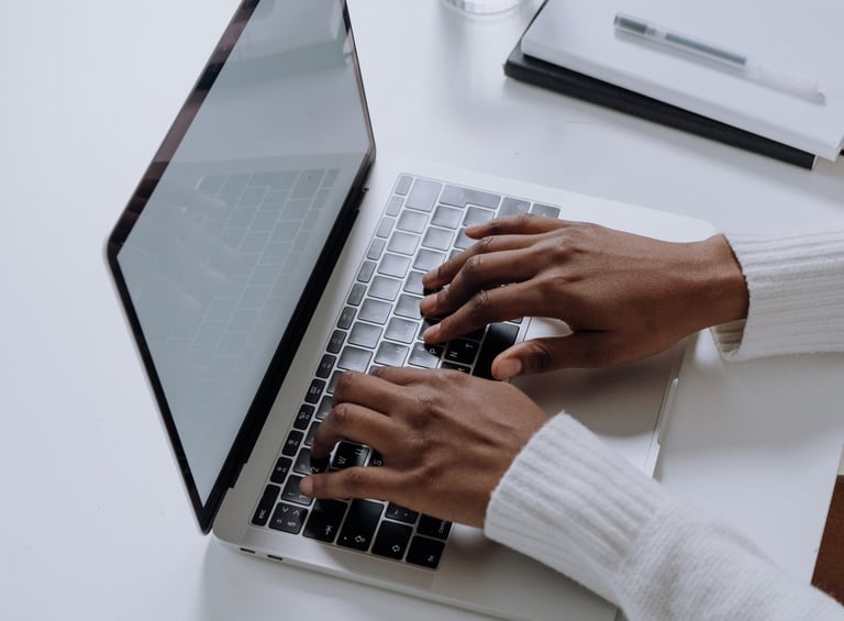a person sitting at a table with a laptop and a glass of water