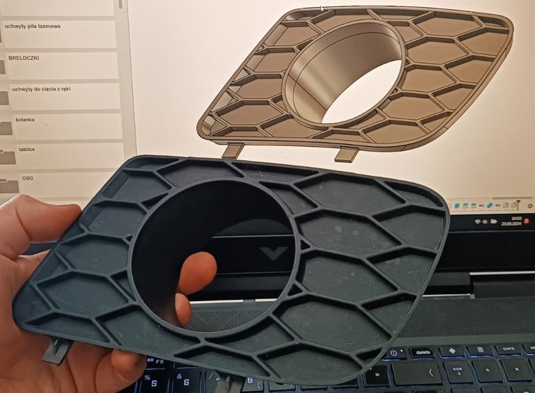 trzyma w ręku prototypowany element samochodu