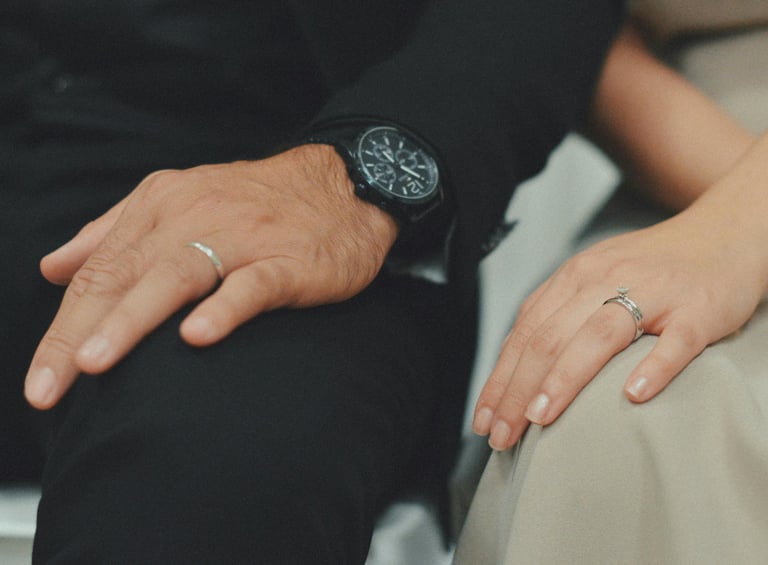 a man and woman holding hands and wearing rings