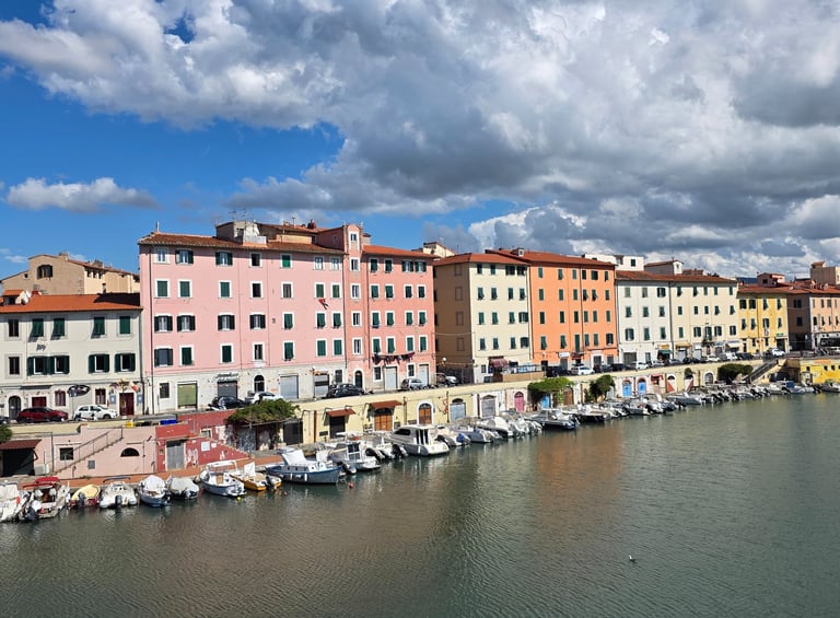 a river with boats and buildings in the background